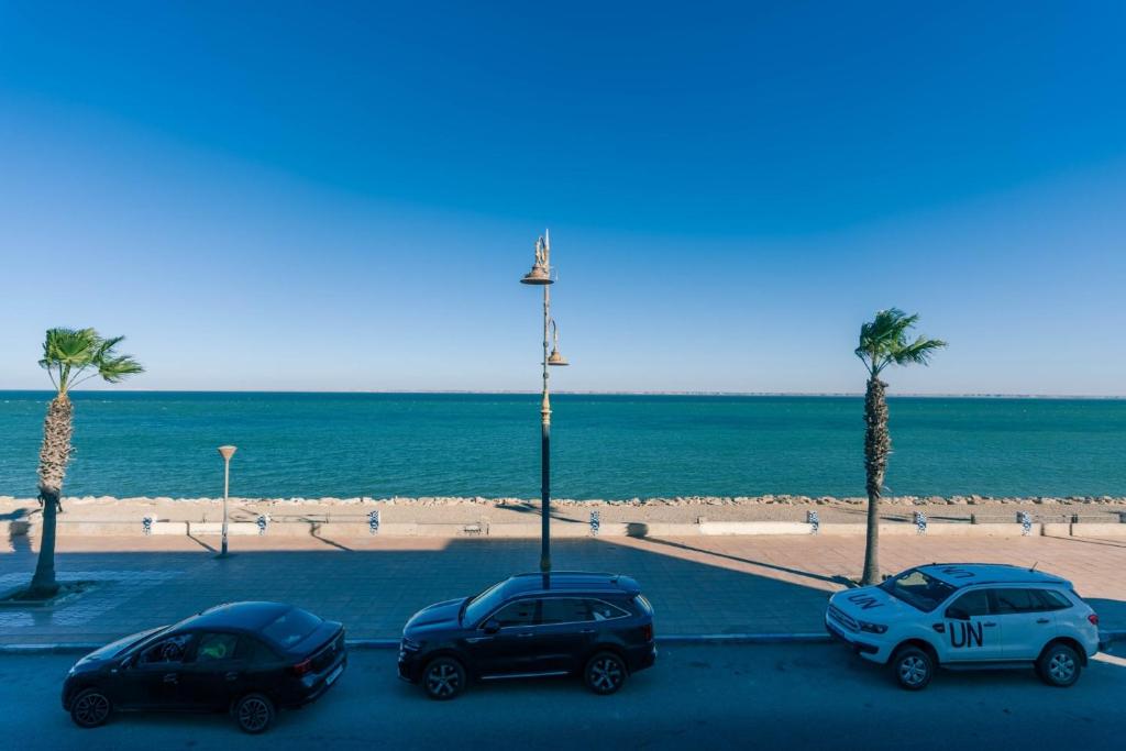达赫拉PLAYA HOTEL的三辆车停在海滩附近的停车场