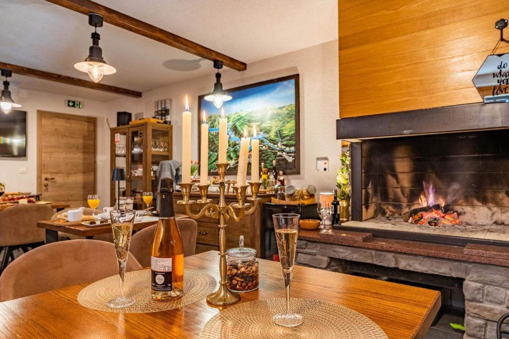普利特维采湖B&B Villa Sumrak Plitvica Rooms的餐桌、酒杯和壁炉