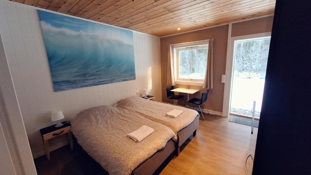 HauggrendTelemark Motel and Apartment的卧室配有一张床,墙上挂着一幅大画