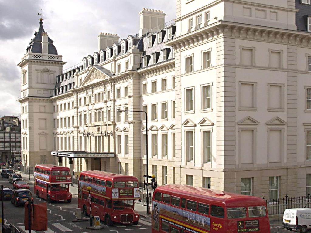 伦敦希尔顿伦敦帕丁顿酒店的两辆红色双层巴士,在城市街道上