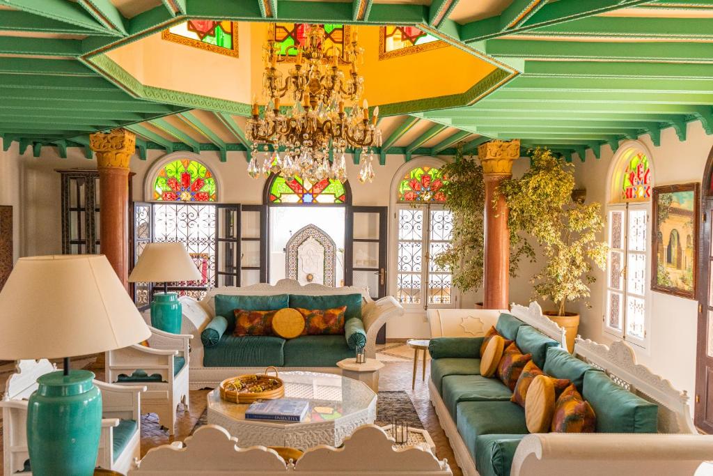 丹吉尔Lalla Soulika的客厅配有绿色沙发和吊灯。