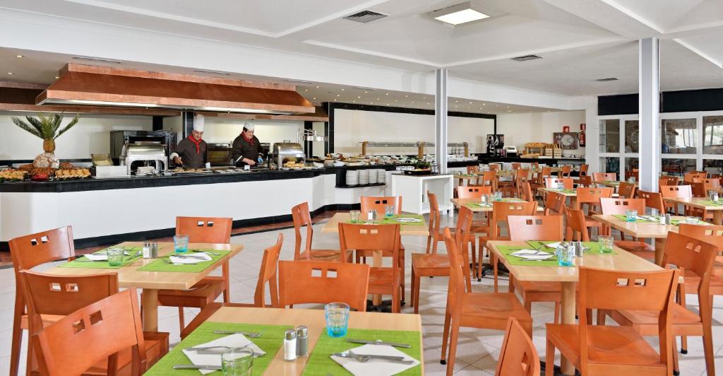 卡拉斯马略卡AluaSun Cala Antena - All Inclusive的一间带桌椅的餐厅和一间厨房