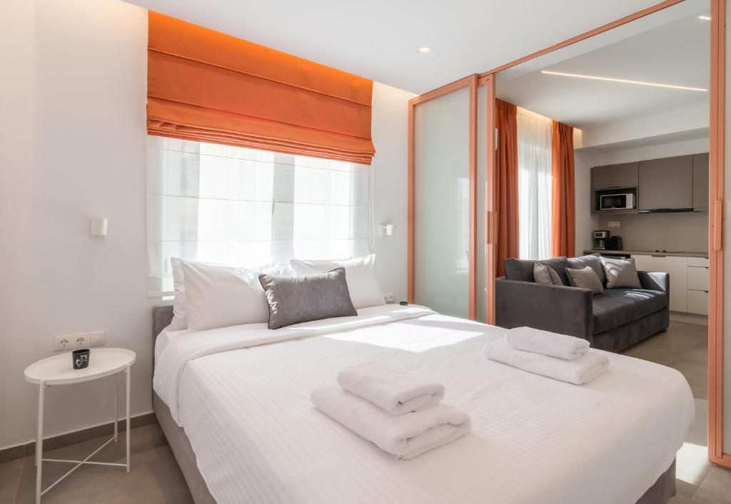 雅典Athens Theatrou Apartments的卧室配有带毛巾的大型白色床