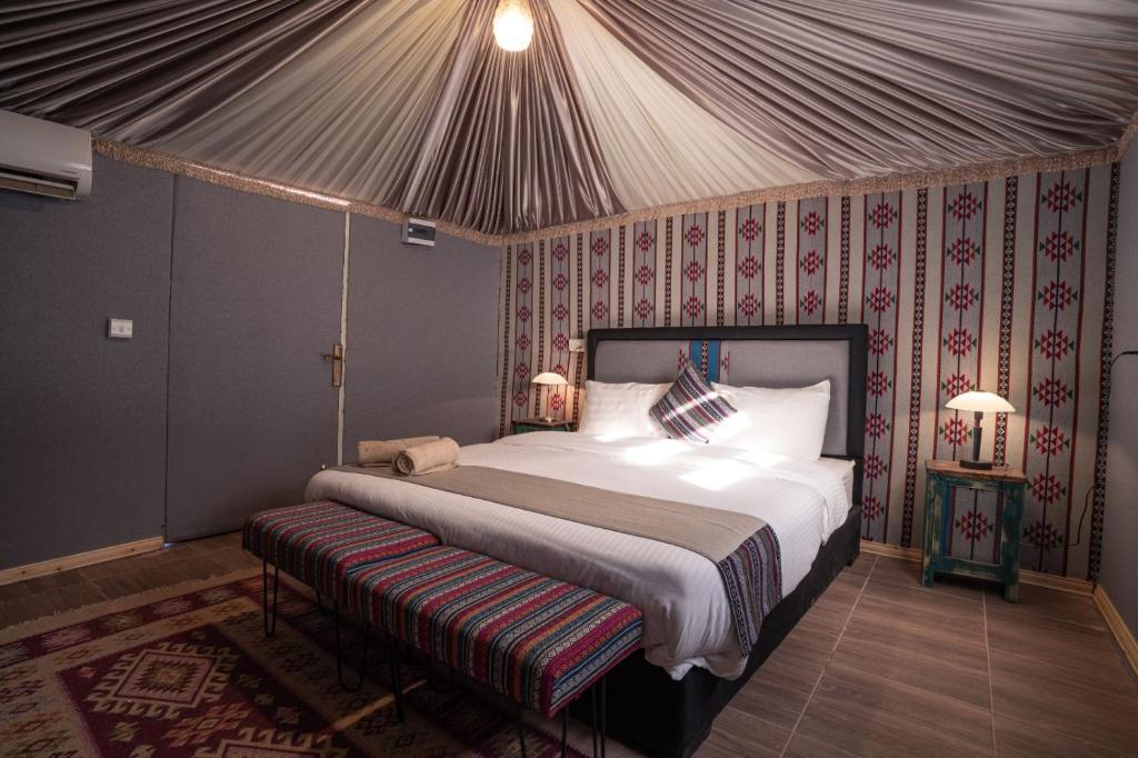 瓦迪拉姆迎宾沙漠营地酒店的帐篷内一间卧室,配有一张大床