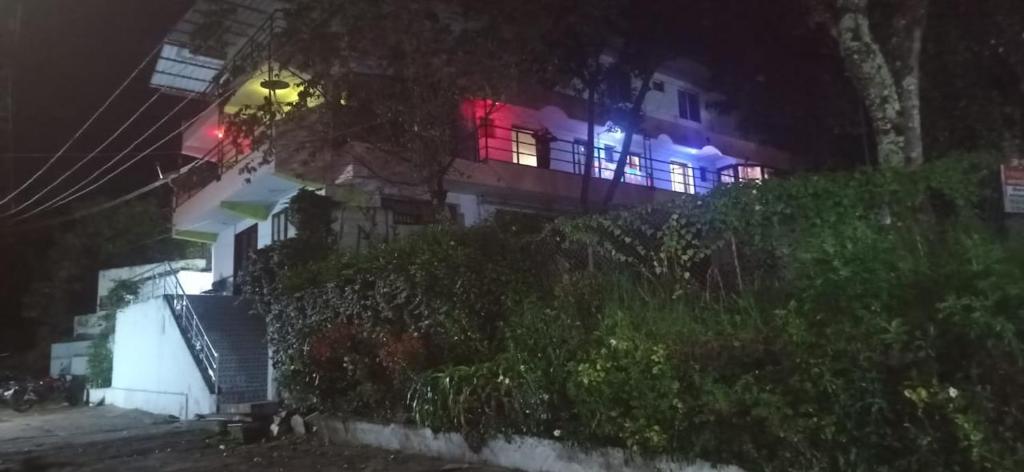 科代卡纳尔Sugan Residency的夜晚有红蓝色的灯光的房子