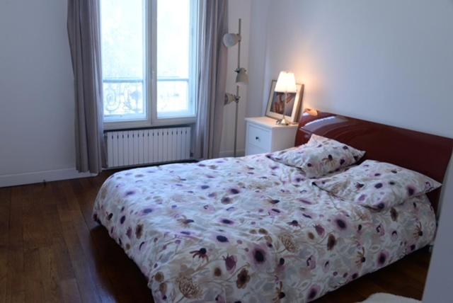 巴黎Eiffel Edge Escape的一间卧室配有一张带鲜花毯子的床