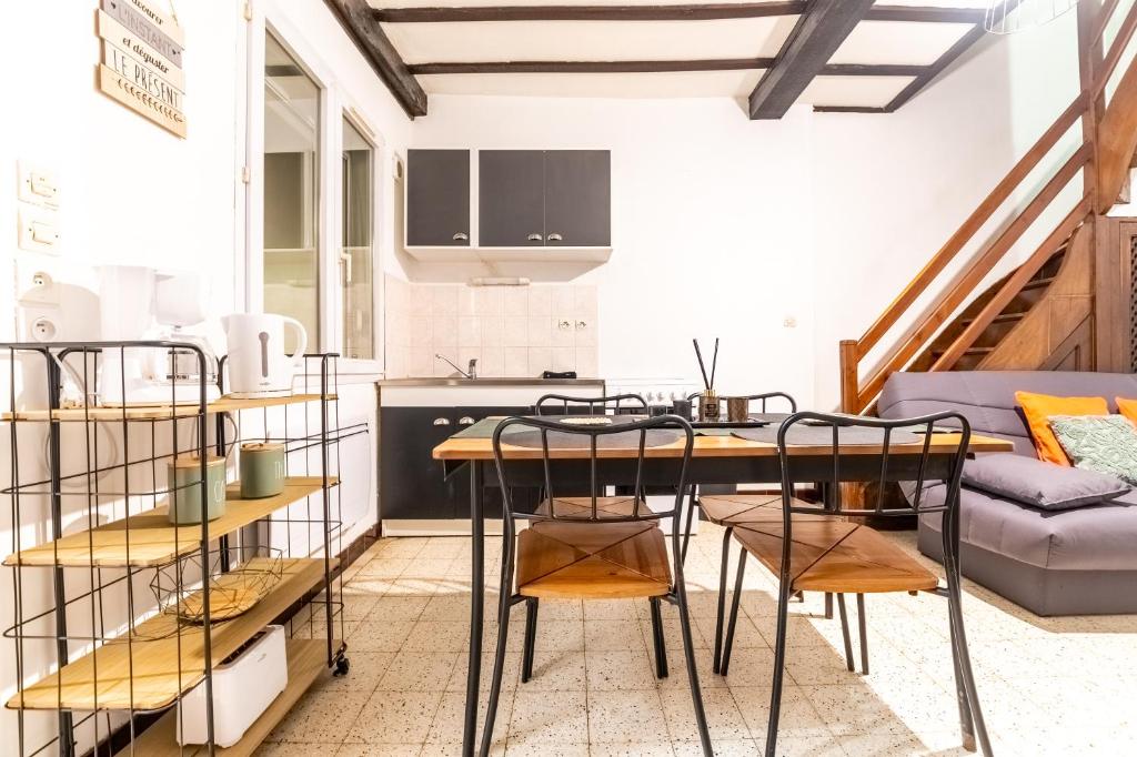 阿布维尔Le Nairobi, Abbeville的厨房以及带桌椅的起居室。