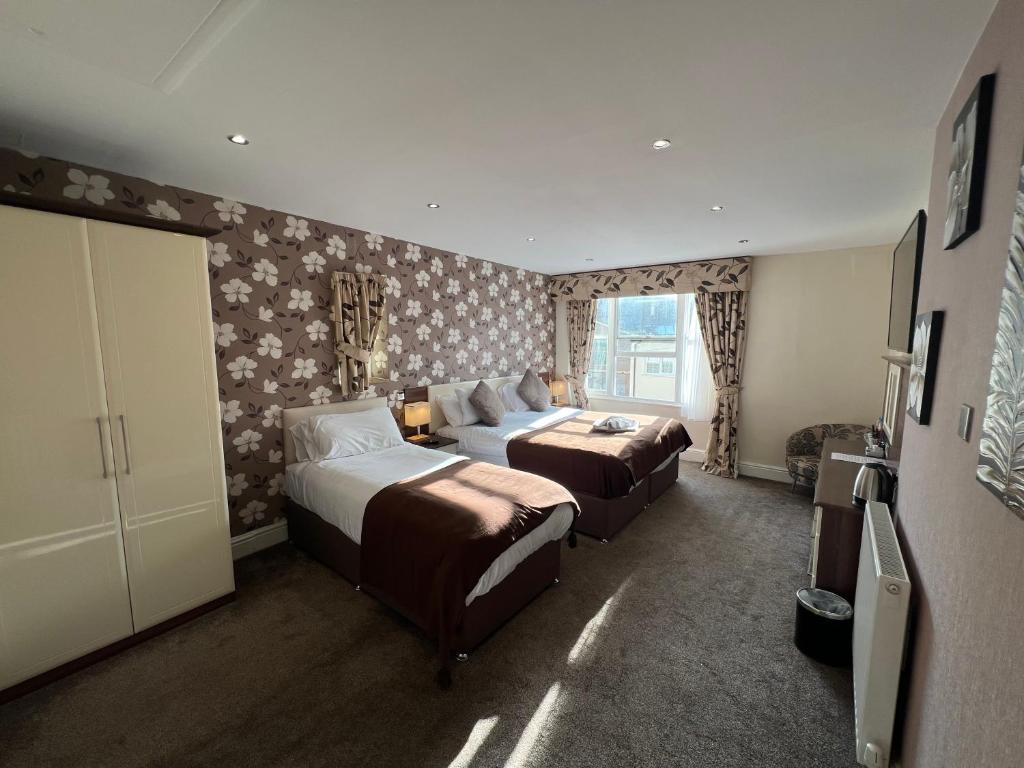 兰迪德诺Lauriston &amp; Lawton Court Hotel的有两张床和一扇窗户的酒店房间