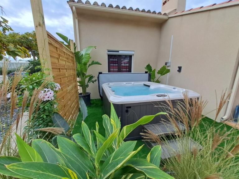 佩皮尼昂Maison individuelle plain pied avec Spa en option的房屋的院子内的热水浴池
