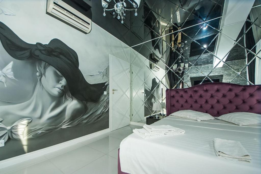 加拉茨Apartament Sweet Luxury的一间装饰有一幅画画的女人帽子的卧室