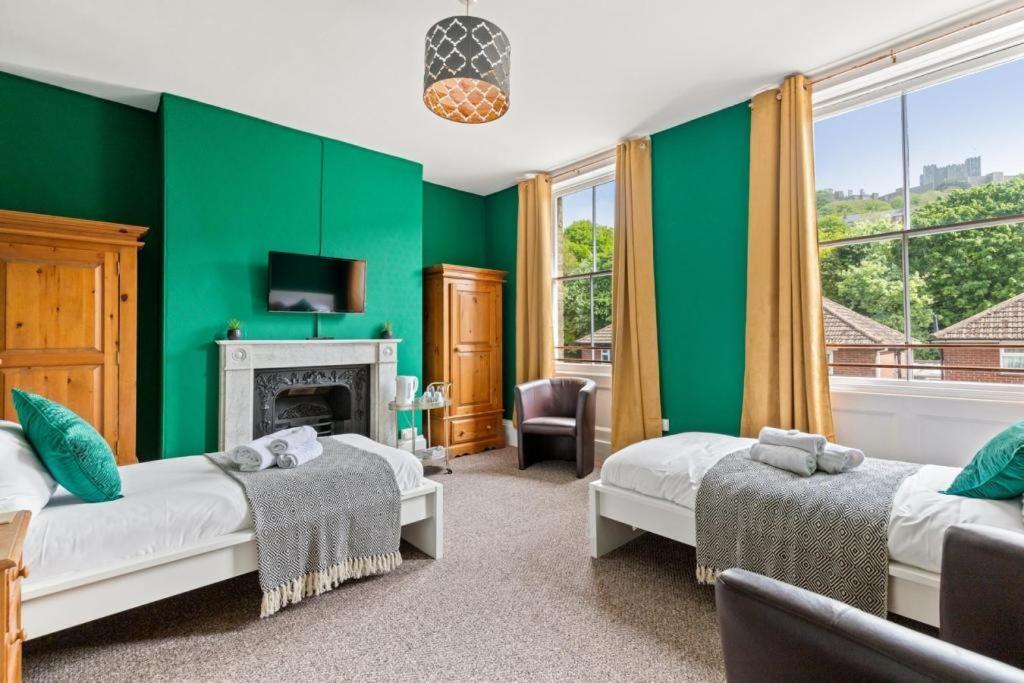 多佛尔Dover Town Rooms - Short Lets & Serviced Accommodation - Dover的绿色的客房设有两张床和壁炉