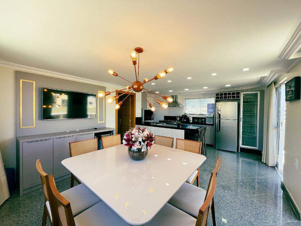 邦比尼亚斯Residencial 364 - Localização privilegiada à 5min da praia的厨房以及带白色桌椅的用餐室。