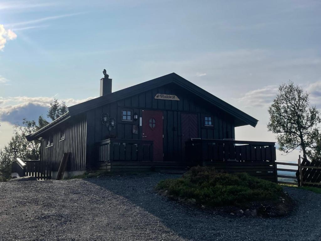 MesnaliHytte med Anneks og fantastisk utsikt på Ljøsheim的一个带红色门的大木仓