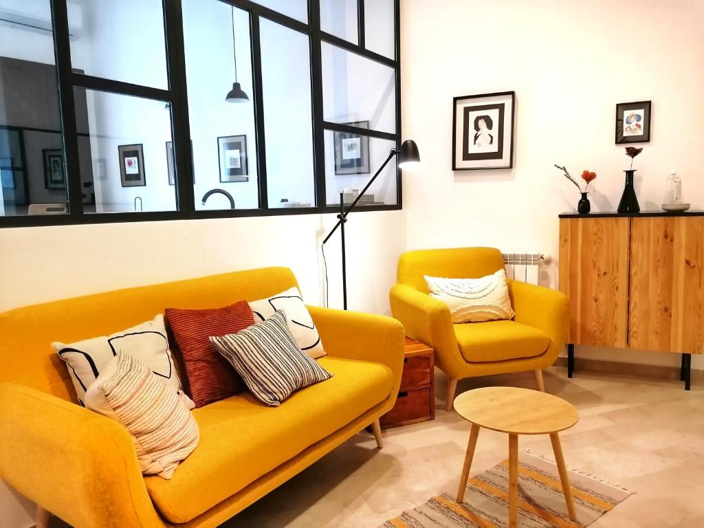 巴勒莫I Canti Comfort Rooms的客厅配有黄色的沙发和椅子