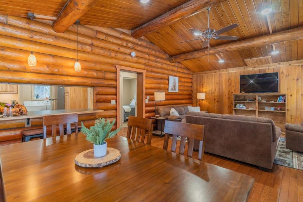 费尔班克斯The Alaskan Dream Lodge的用餐室和带木制天花板的客厅