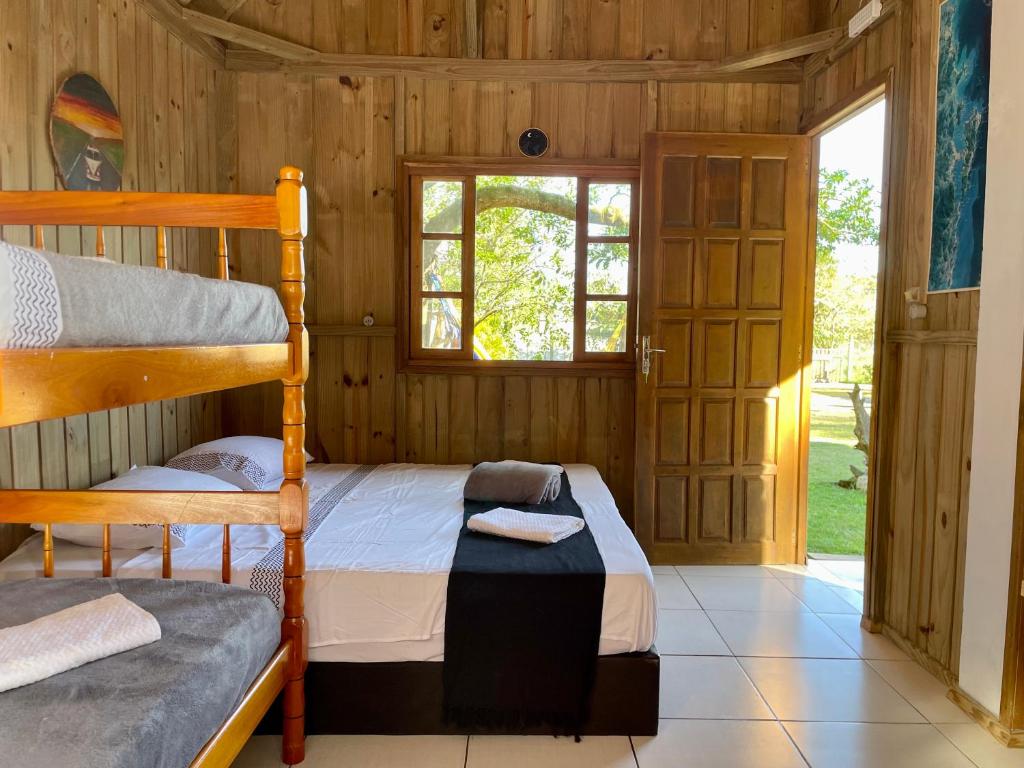 普腊亚罗萨Pousada Lua de Java - Casa Bali的一间卧室设有两张双层床和一扇窗户。