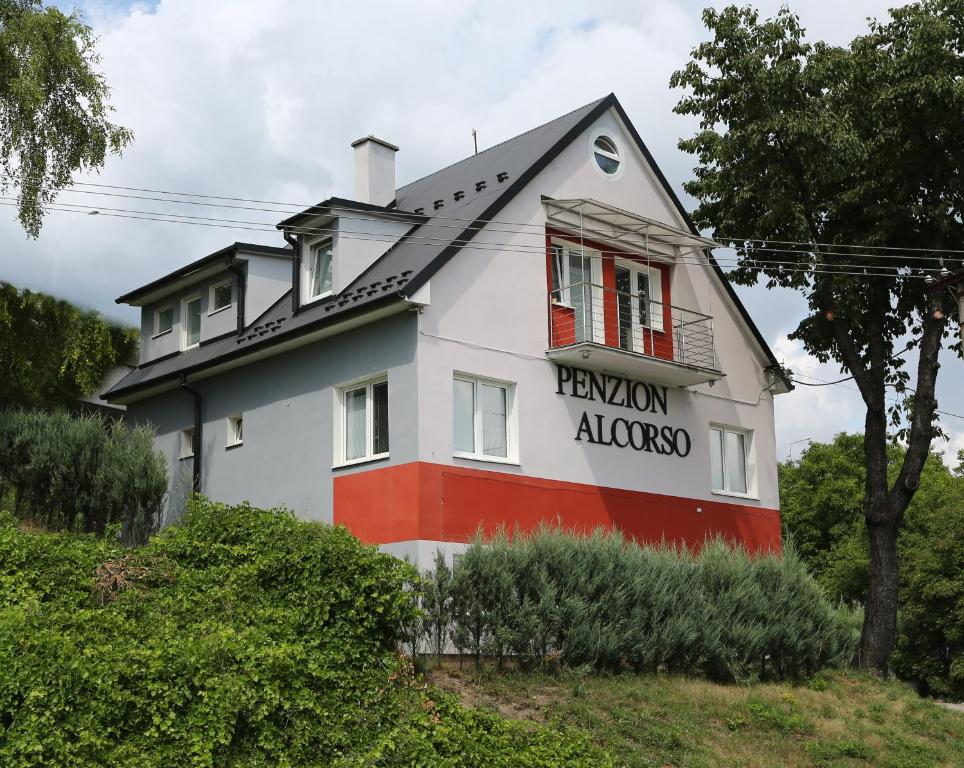 班斯卡-比斯特里察Alcorso Pension的白色和红色的房子,上面有标志