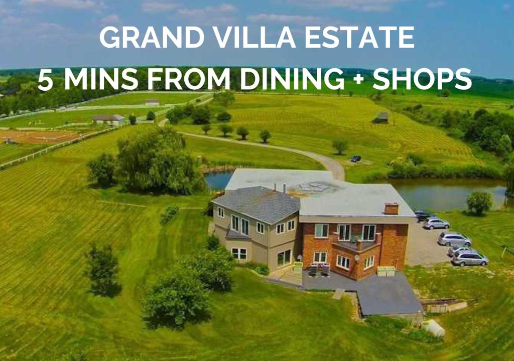 伯灵顿Grand Villa Estate的一座大房子,位于一座草木小山上,拥有5座宏伟的别墅