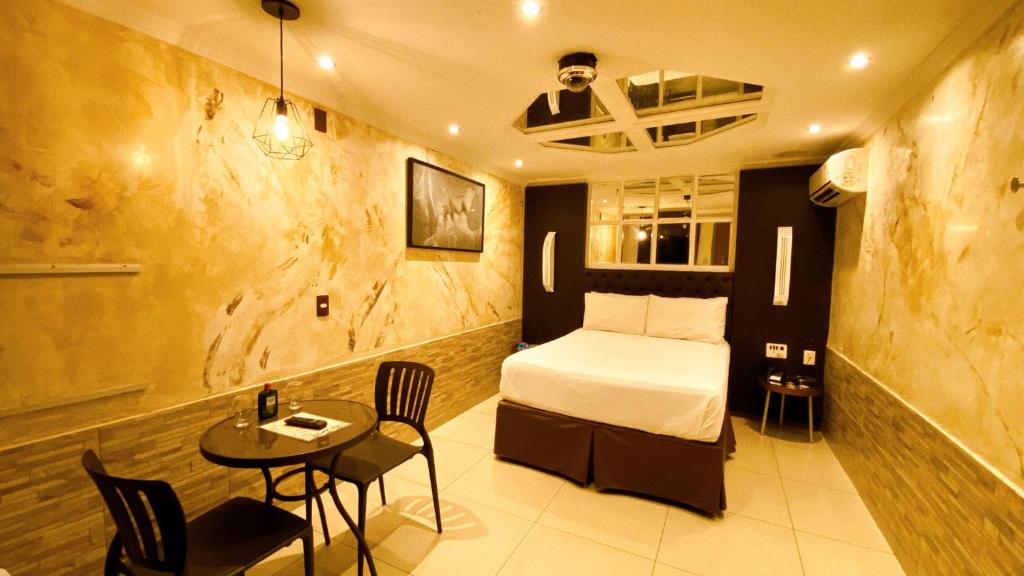 纳塔尔Motel Ceki Sabe的卧室配有一张床和一张桌子及椅子