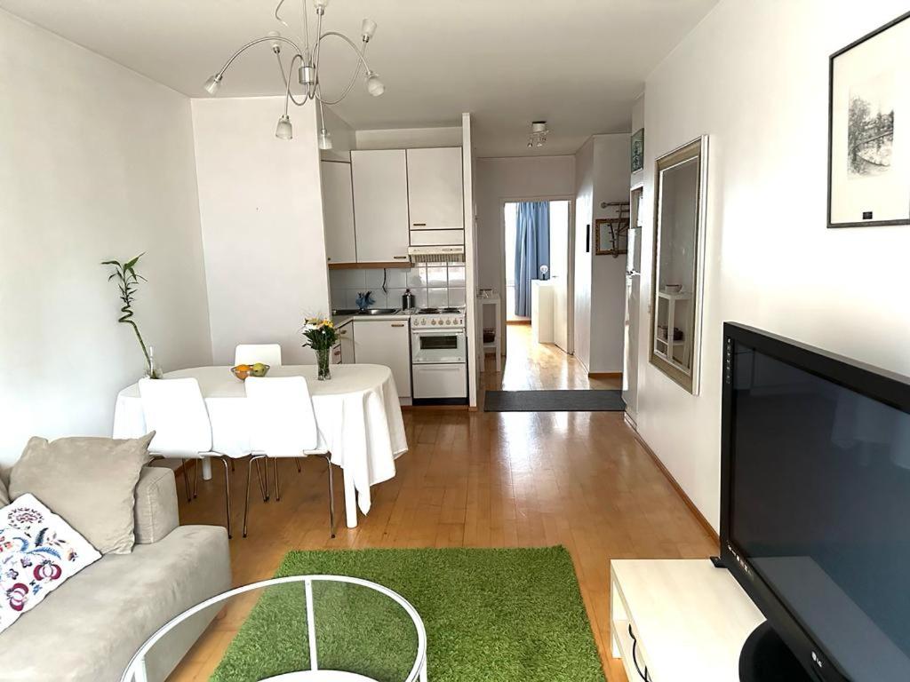 赫尔辛基Spacious 2 rooms apartment in Helsinki Design District, own balcony的带沙发和桌子的客厅以及厨房。