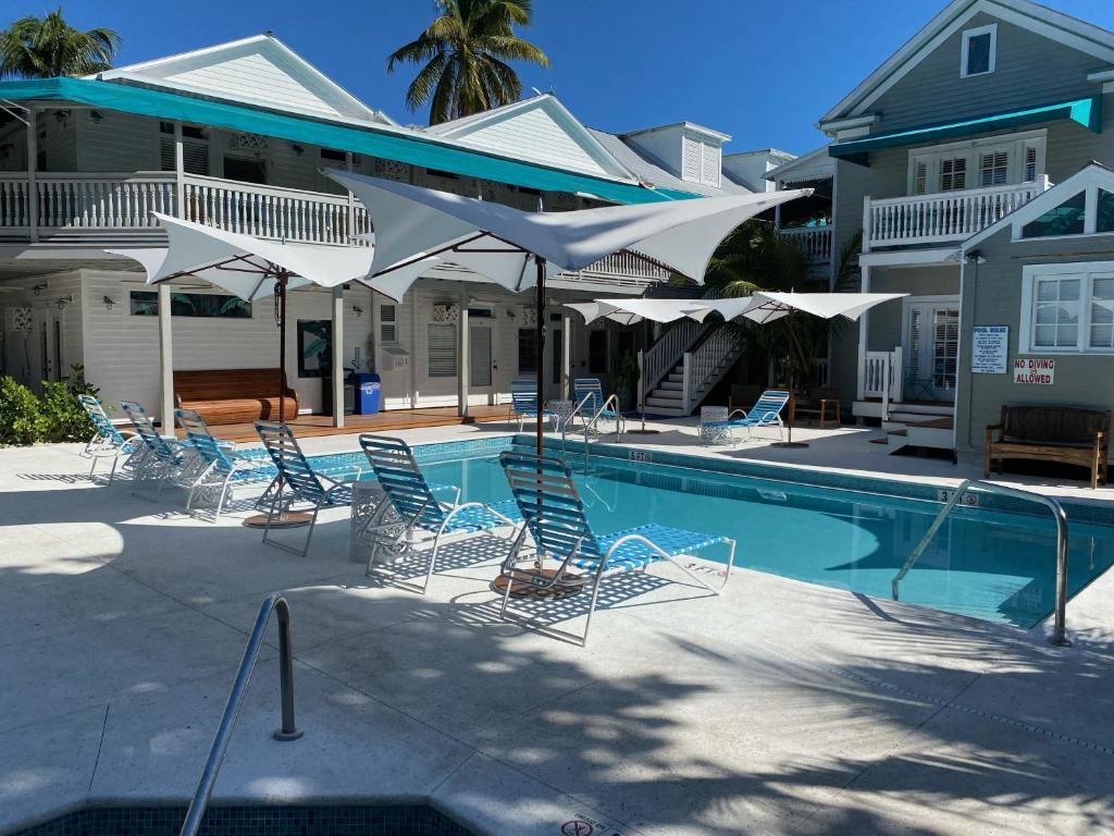 基韦斯特伊登豪斯酒店的房屋旁的游泳池配有椅子和遮阳伞