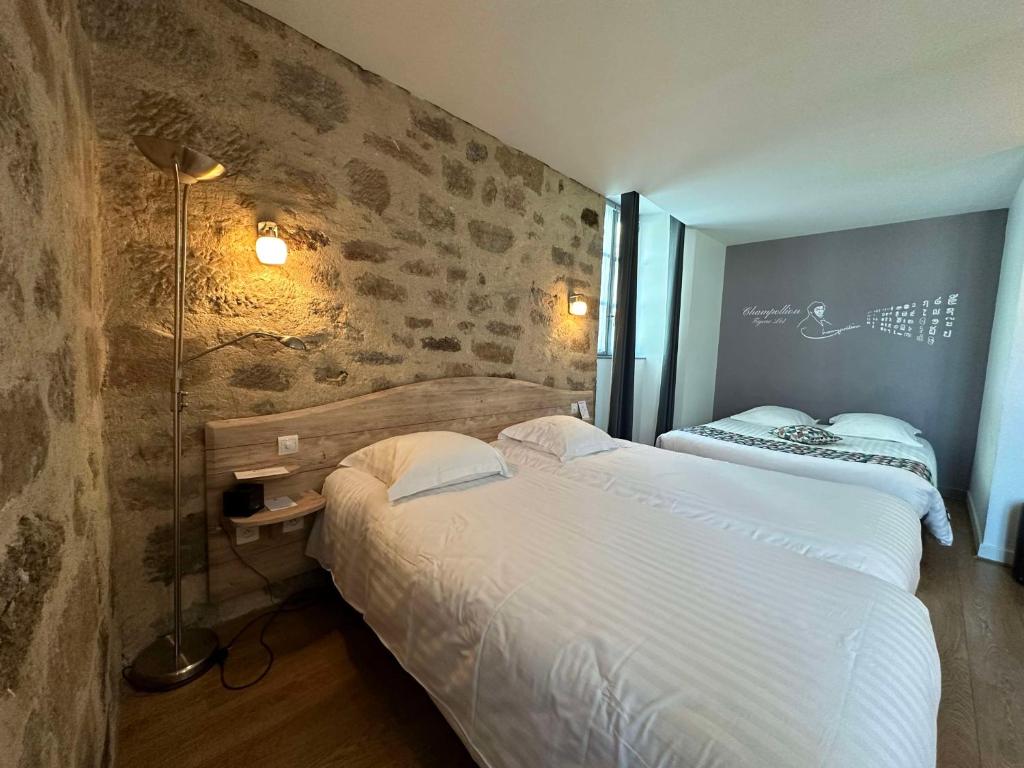 菲雅克朋杜贝斯特韦斯特酒店的一间卧室设有两张床和砖墙
