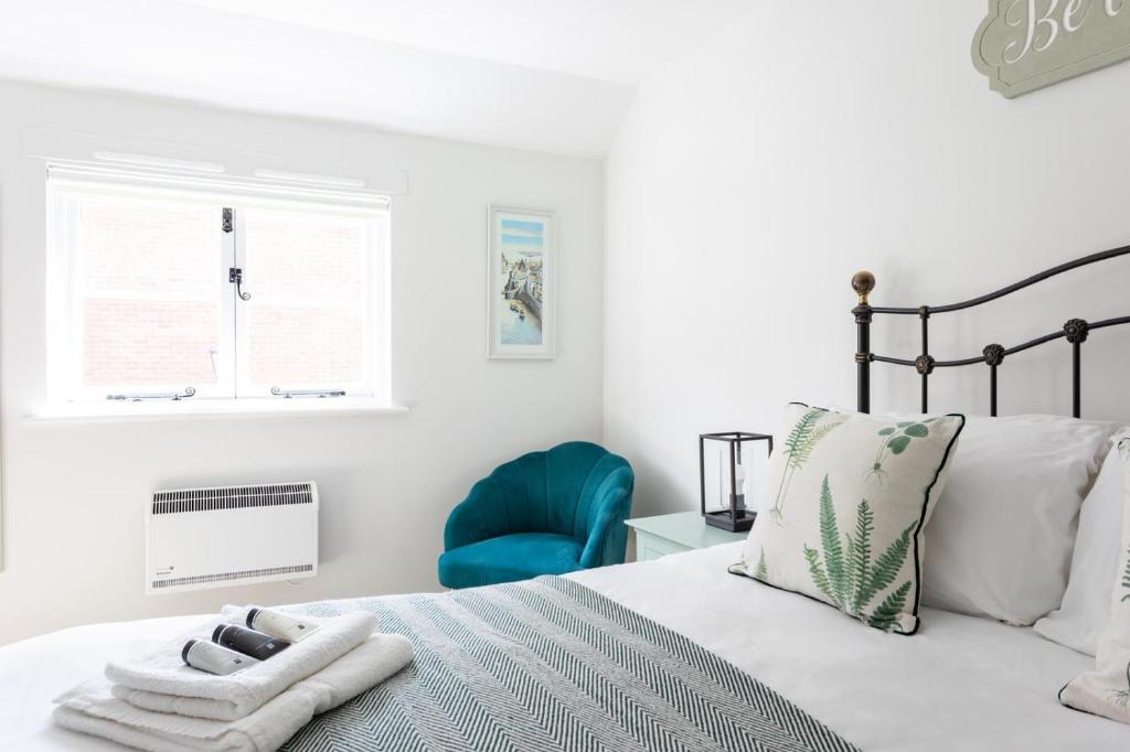 莫尔登Maldon Executive Apartments的一间卧室配有一张床和一张蓝色椅子