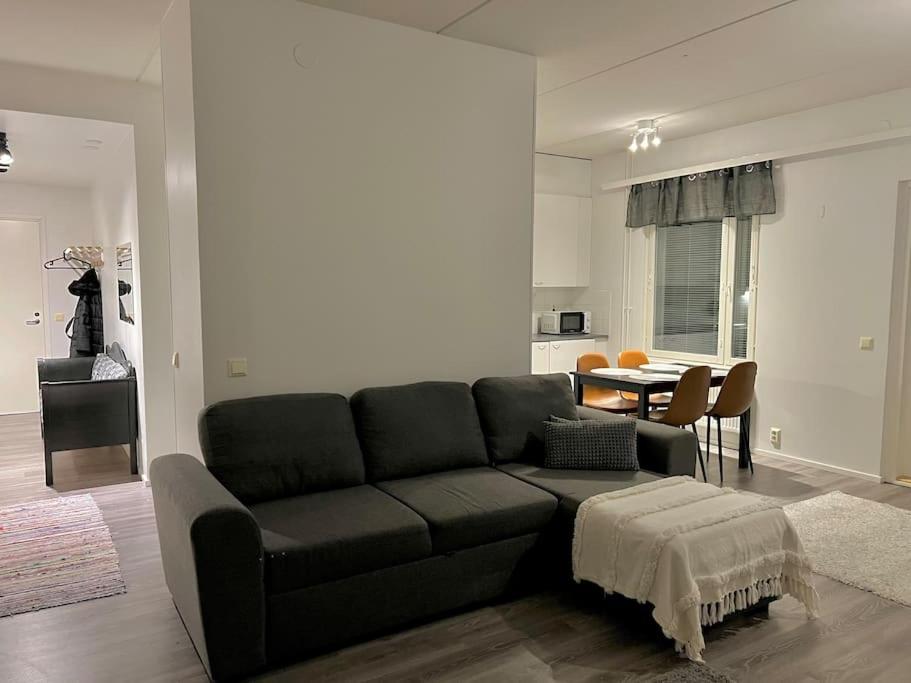瓦萨Apartment Korsholma1的客厅配有黑色沙发和桌子