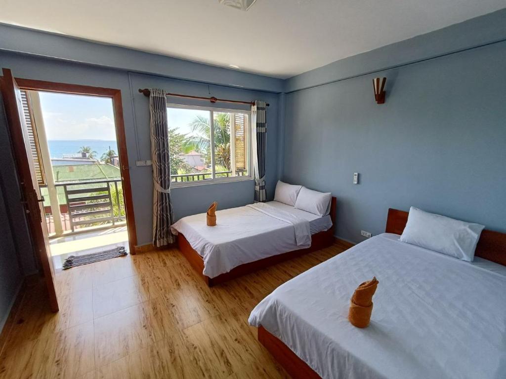瓜隆岛Roomy Guesthouse的一间卧室设有两张床和大窗户