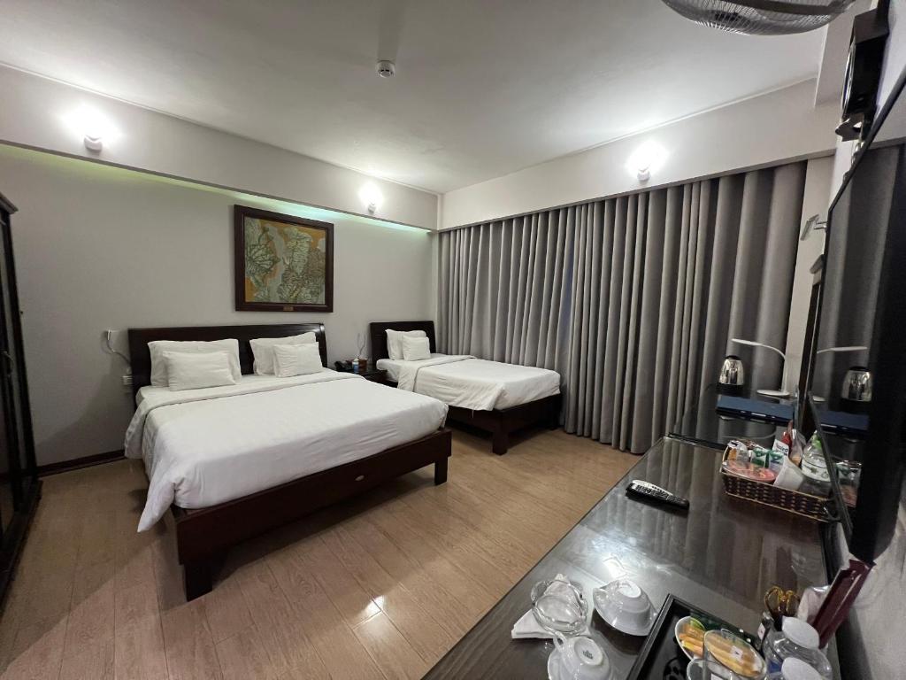 河内A25 Hotel - 88 Nguyễn Khuyến的酒店客房设有两张床和一张桌子。