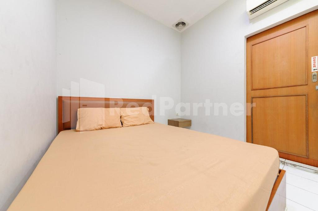 雅加达Orange Garden 47 Mitra RedDoorz的一间白色客房内的床铺卧室