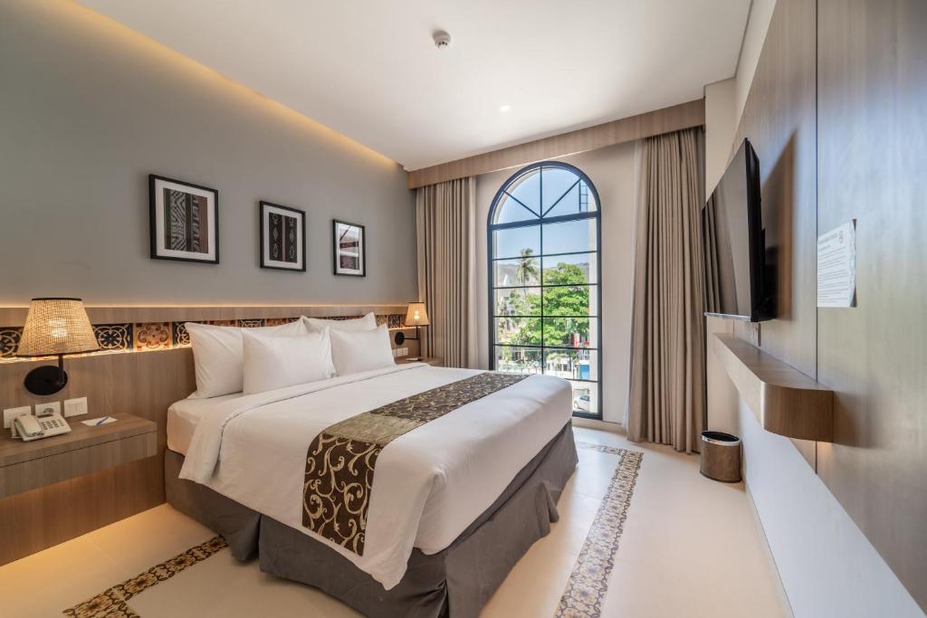 龙目岛库塔MONTANA @OCEANSIDE MANDALIKA的酒店客房设有床和窗户。