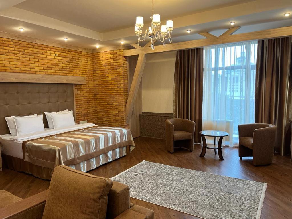 阿拉木图CITY STAY Апарт-Отель Алматы的酒店客房带一张床、一张桌子和椅子