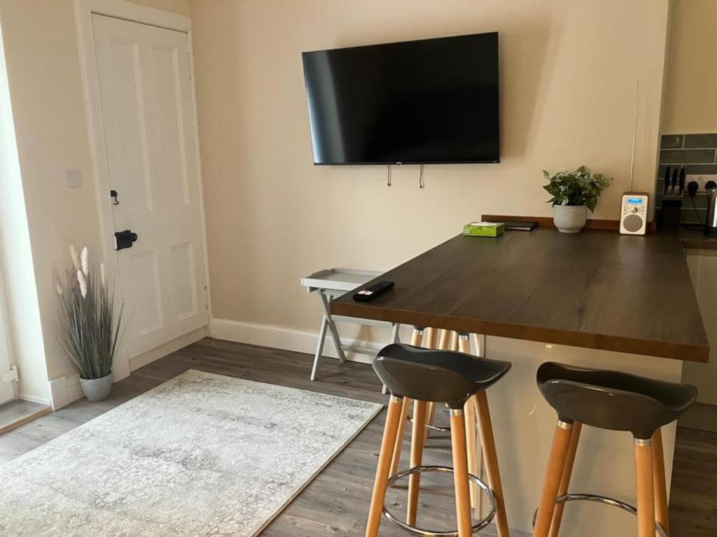圣安德鲁斯St Andrews - 5 min walk to centre的客厅配有一张桌子、凳子和墙上的电视