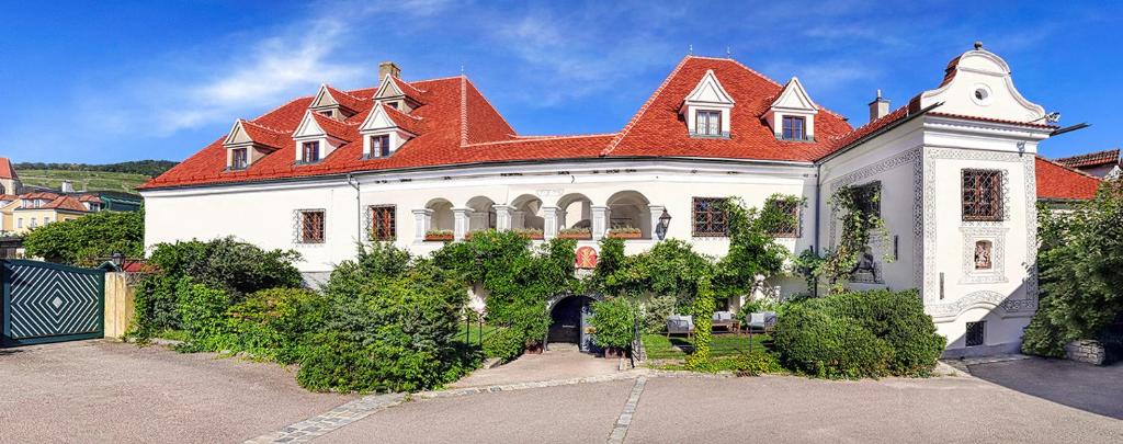 瓦豪地区魏森基兴拉夫斯伯格霍夫文艺复兴住宿加早餐旅馆的一座大型白色房屋,设有红色屋顶