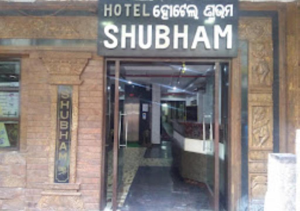 RourkelaHotel Shubham Odisha的建筑的入口,上面有标志