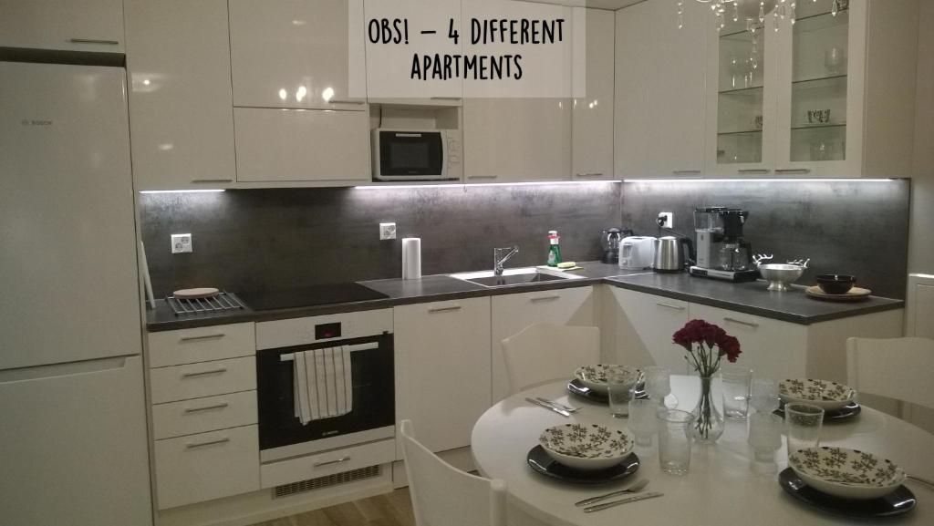 罗瓦涅米皮里科公寓的厨房配有白色橱柜、桌子和水槽。