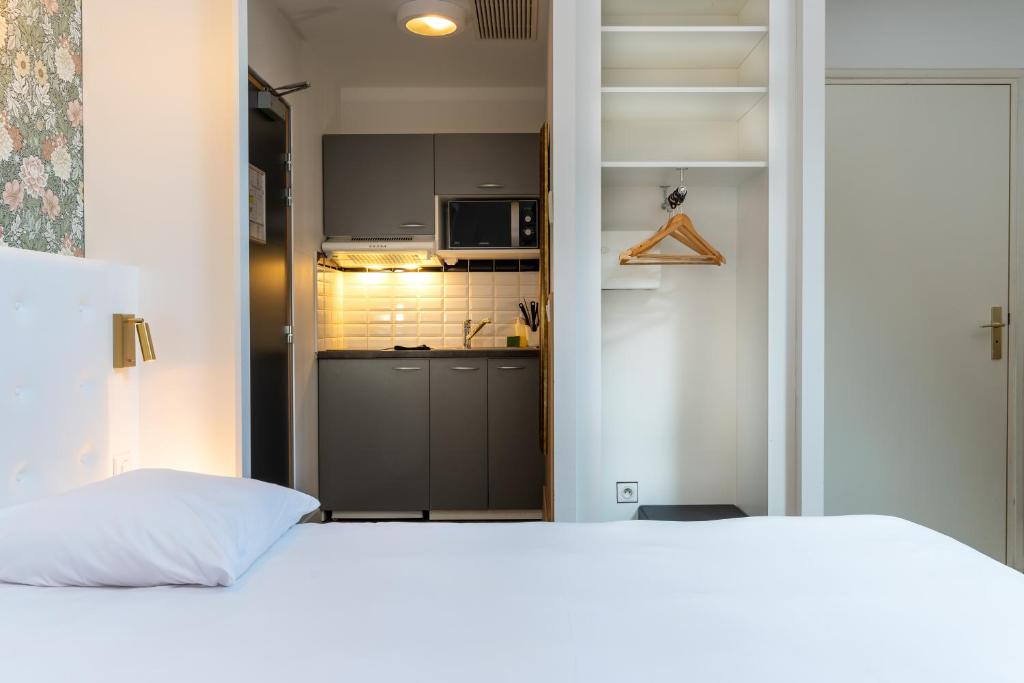 里尔CALM Appart' & Hostel的一间带白色床的卧室和一间厨房