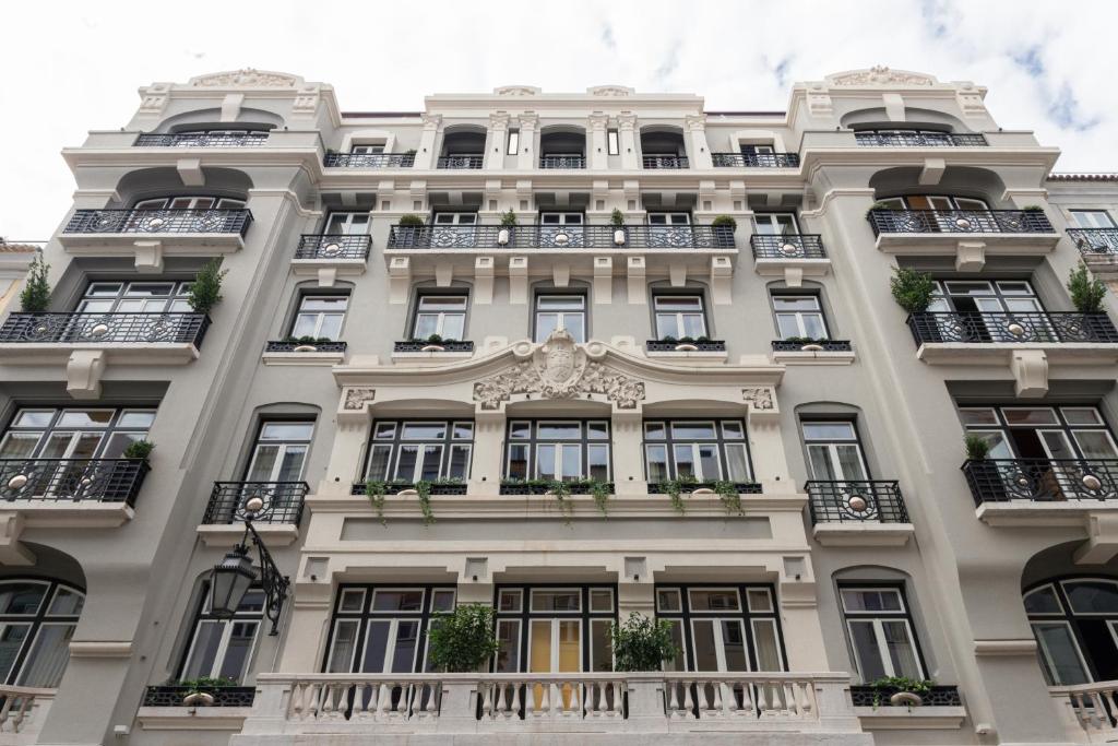 里斯本Art Legacy Hotel Baixa-Chiado的一座高大的白色建筑,设有窗户和阳台