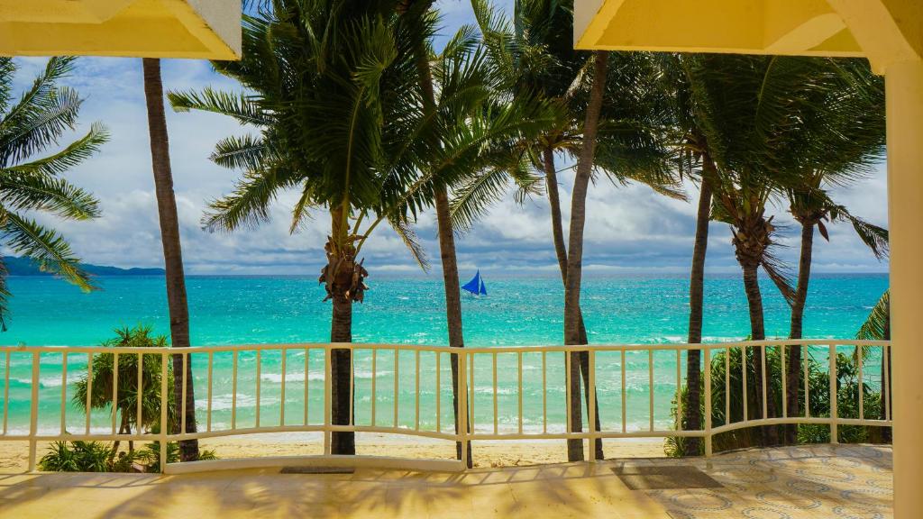 长滩岛Boracay Sea View Hotel的阳台享有大海和棕榈树的景致。