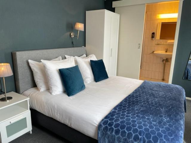 法尔肯堡Hotel De la Ruïne的一间卧室配有一张带蓝白色枕头的大床