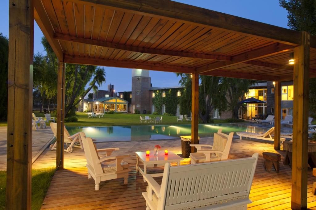 玛德琳港马德林港酒店的一个带白色椅子和桌子的甲板以及一个游泳池