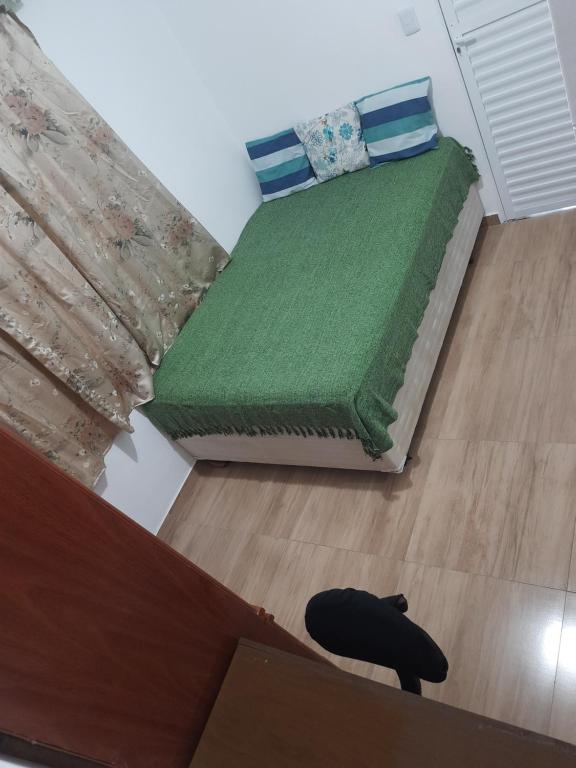 圣若泽杜斯坎普斯Hostel Sancris的一间卧室配有一张带绿色棉被的床