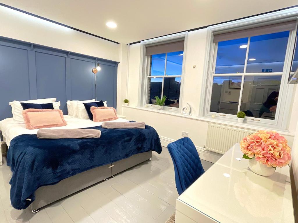 泰恩河畔纽卡斯尔Central penthouse by HNFC Stays的一间卧室设有两张床、一张桌子和窗户。