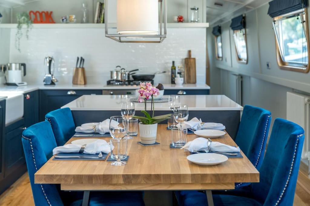 伦敦Luxurious houseboat near Canary Wharf in London的厨房里摆放着一张桌子,四周摆放着蓝色的椅子