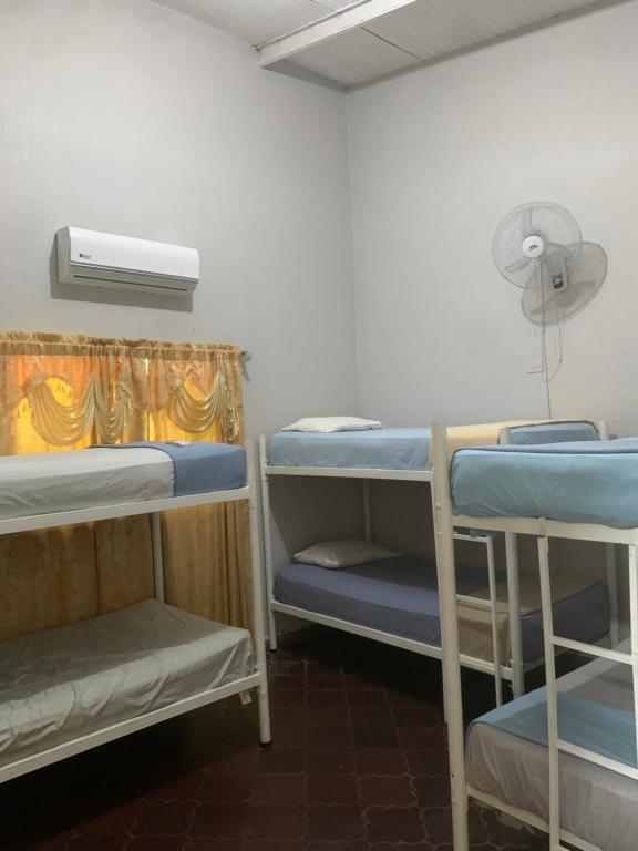 科潘玛雅遗址Stella Hostel Copán的客房设有三张双层床和风扇。