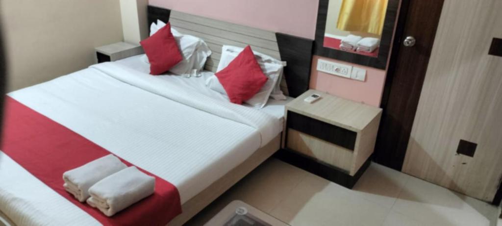 普里Goroomgo Golden Beach Inn Puri Near Sea Beach的一间卧室配有红色和白色枕头的床