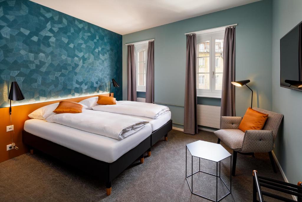 卢塞恩Hotel Münzgasse - Self Check-in的酒店客房,配有两张床和椅子