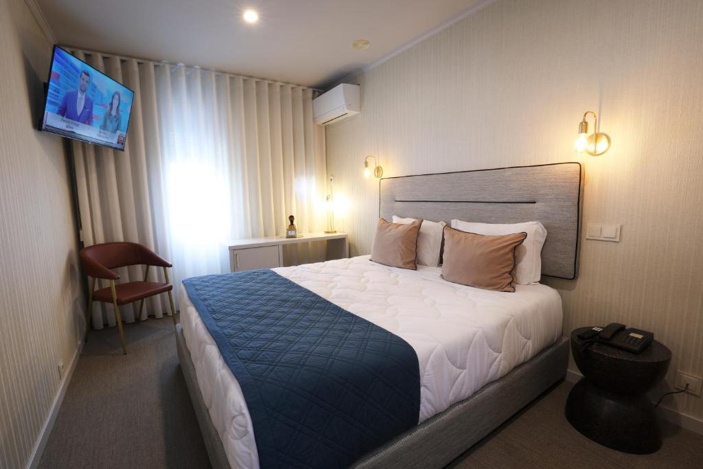 波尔图美洲酒店的一间酒店客房,配有一张床和一台电视