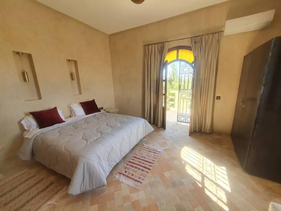 马拉喀什Dar Amali, villa spacieuse 9ch avec piscine en exclusivité的一间卧室设有一张大床和一个大窗户